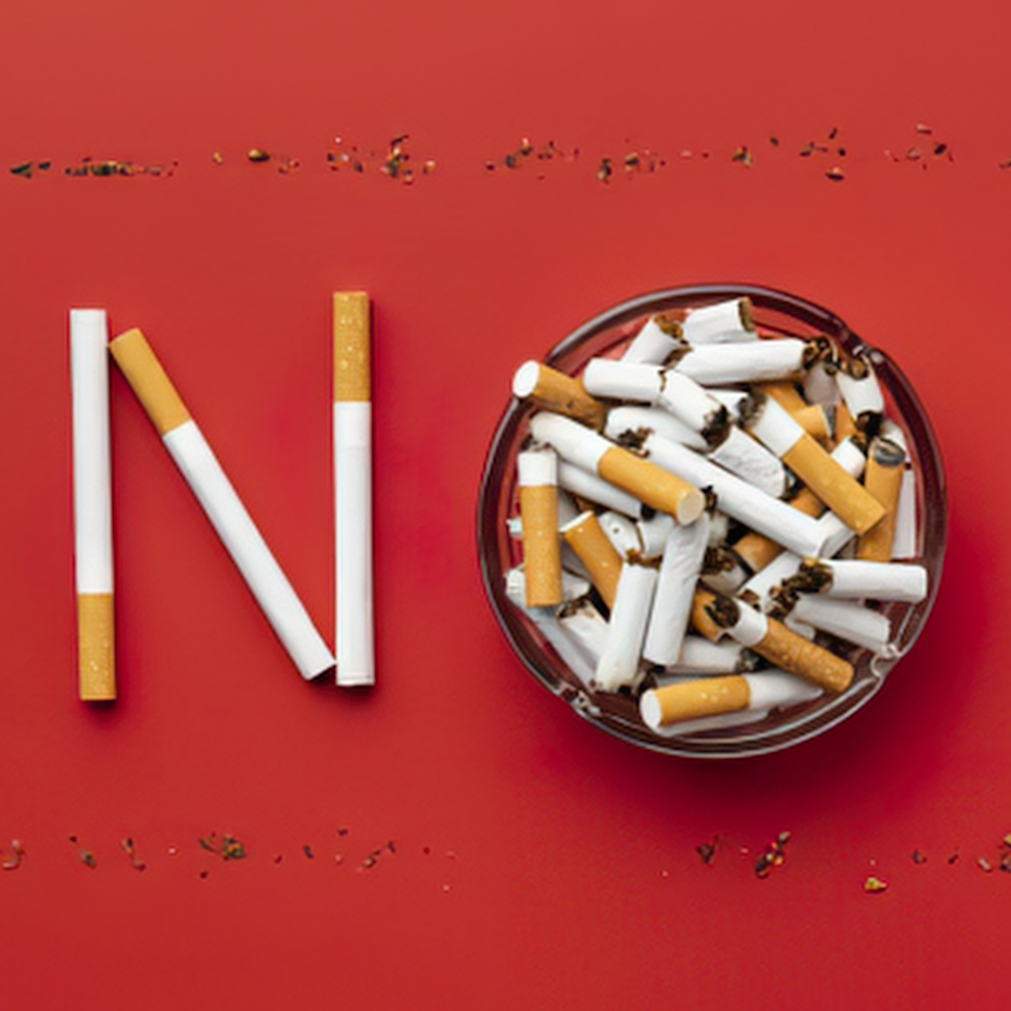 Les perfectionnements : Mot « NO » formé avec des cigarettes sur fond rouge, à côté d’un cendrier rempli de mégots, illustrant un message de refus