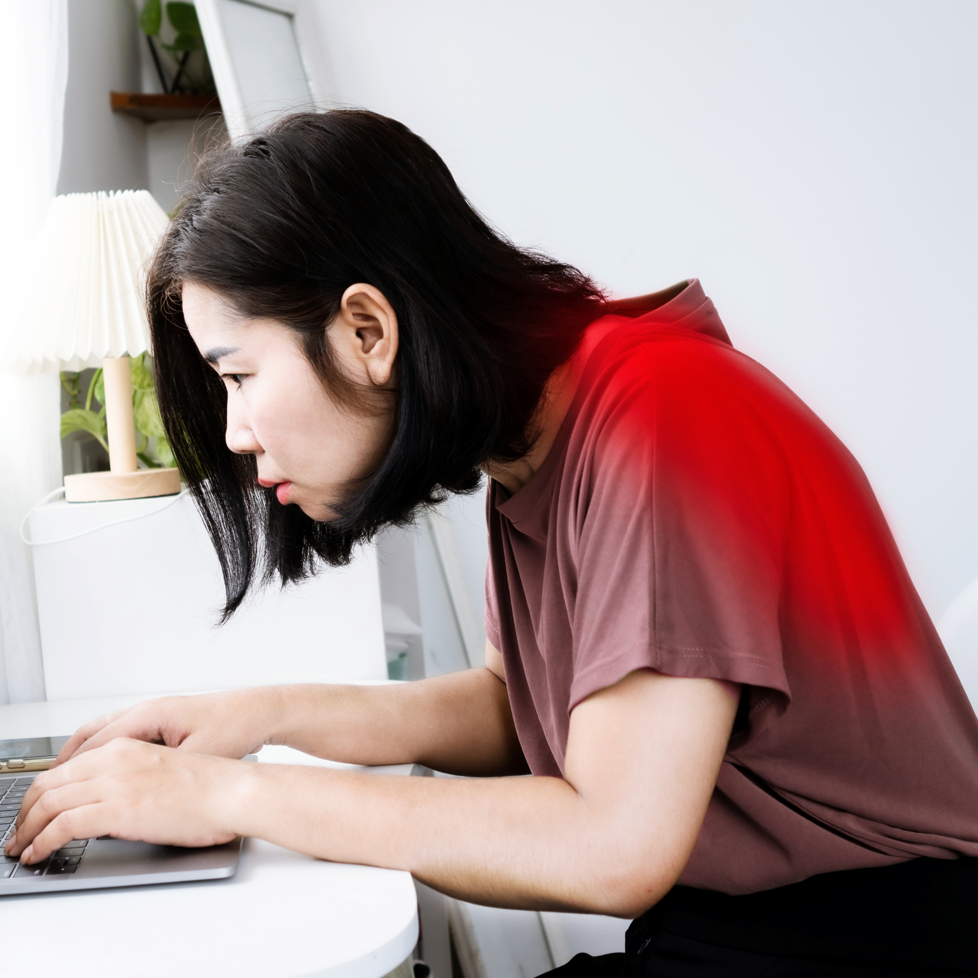 les perfectionnements : Femme penchée vers un ordinateur portable, travaillant dans une posture voûtée, avec une zone rouge au niveau du haut du dos illustrant une douleur ou une tension musculaire.